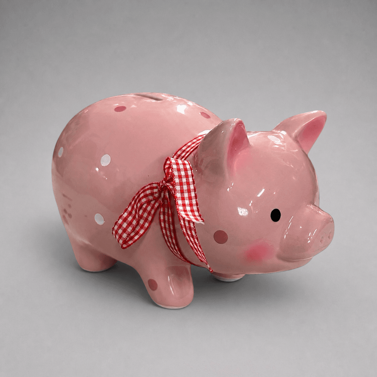 Pink ceramic piggy bank with ribbon