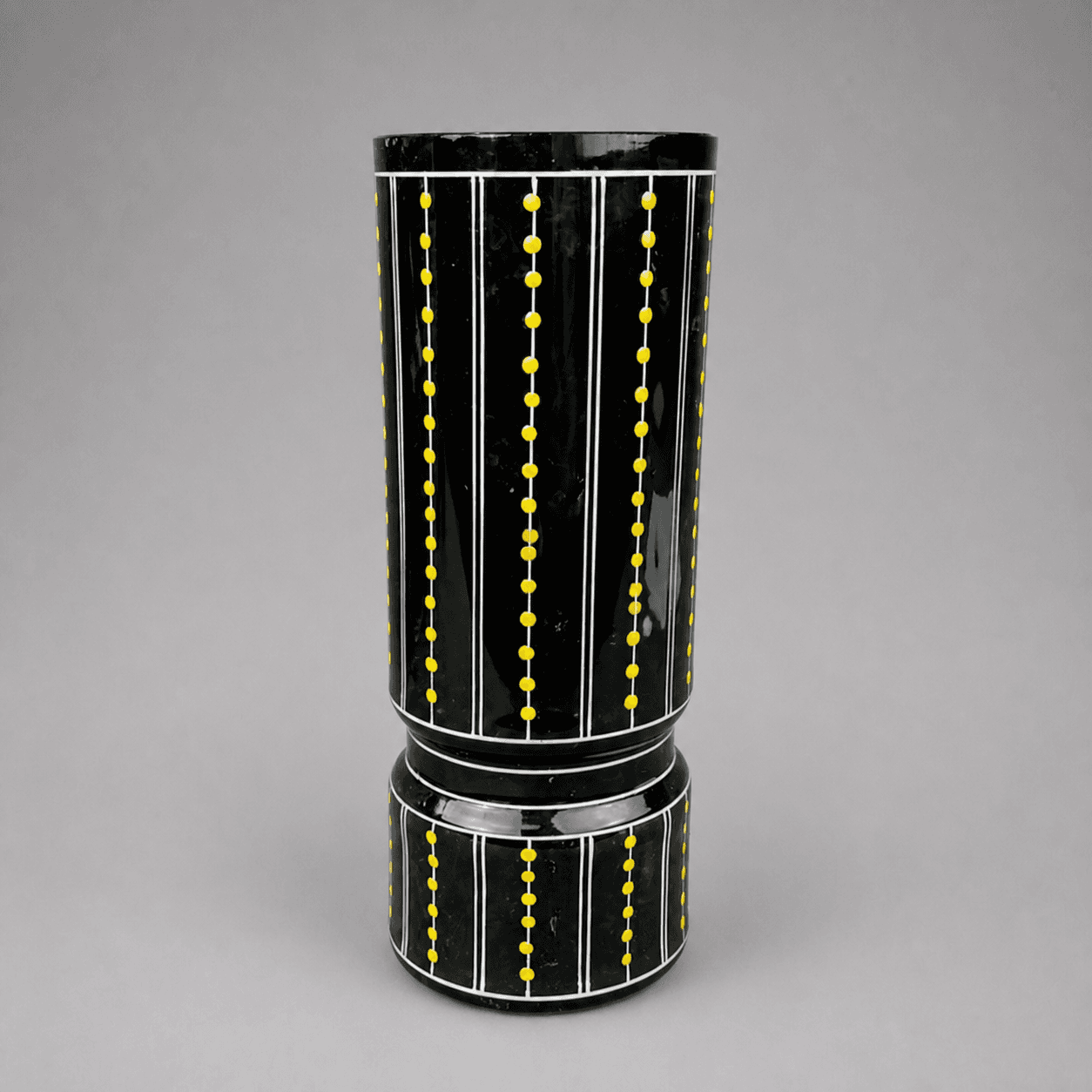 Black cylindrical vessel with yellow dots — Photo 1